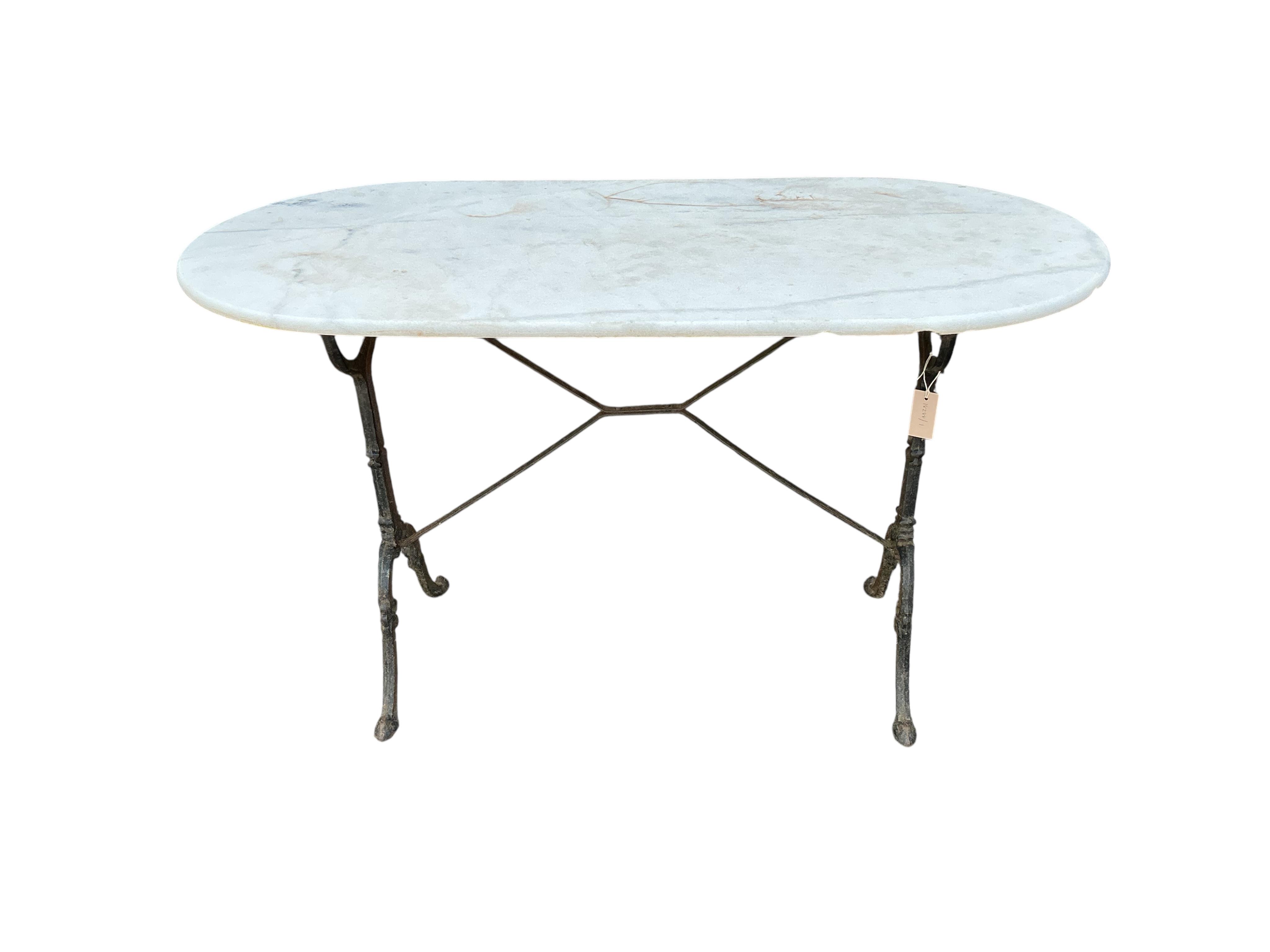An oval reconstituted marble and cast iron garden table, width 120cm, depth 60cm, height 71cm